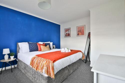 a bedroom with a blue accent wall and a bed at StayRight 3BR House- Multiple Private Parking Spots - Modern Kitchen in Barry