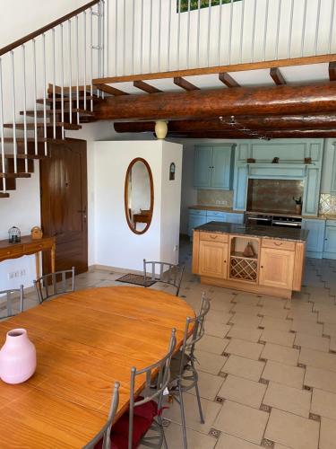 une salle à manger avec une table et des chaises en bois dans l'établissement villa 10 personnes au soleil, à Cavillargues