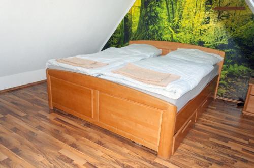 a wooden bed in a room with a painting on the wall at Unter den Sternen in Bottrop