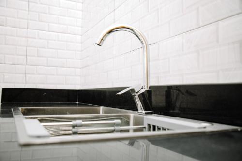 達累斯薩拉姆的住宿－ESN LODGES & HOMETSAY SERVICES，带水龙头的厨房内的盥洗盆
