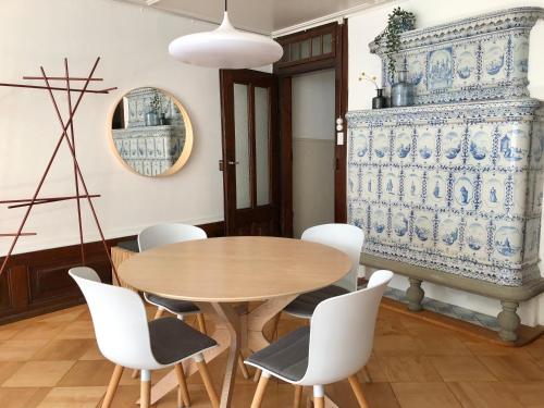a dining room with a wooden table and white chairs at Historical and Modern Flat by Zytglogge - 2nd floor in Bern