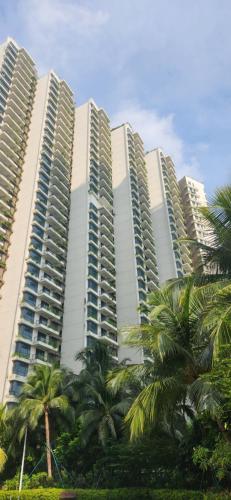 un grand bâtiment avec des palmiers devant dans l'établissement Seaview Regalia Park, (Happy House), Full Furnished, Free WiFi Forestcity, à Gelang Patah