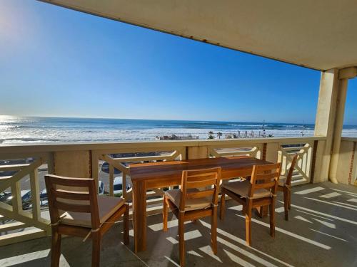 a table and chairs on a balcony overlooking the beach at Résidence Pasino in Lacanau-Océan