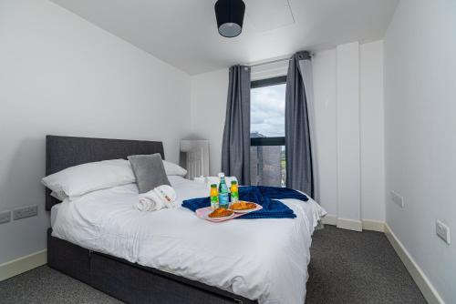 a bedroom with a bed with a tray of food on it at K Suites - 585 London Road in Colnbrook