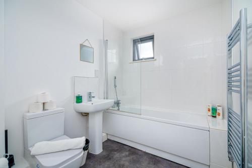 a white bathroom with a sink and a toilet at K Suites - 585 London Road in Colnbrook