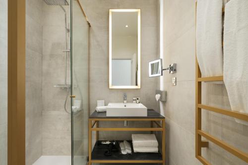 La salle de bains est pourvue d'un lavabo et d'une douche. dans l'établissement Vestay Montaigne, à Paris