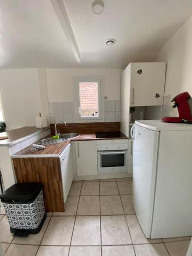 une cuisine avec des armoires blanches et un réfrigérateur blanc dans l'établissement Maison à Pouilly en Auxois, à Pouilly-en-Auxois