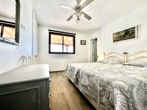 een slaapkamer met een bed en een plafondventilator bij Poolside Villa, Golf del Sur in San Miguel de Abona
