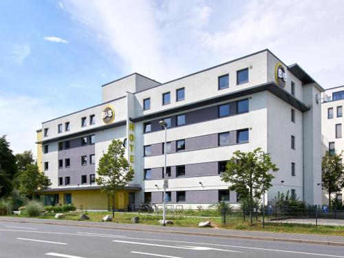 un edificio bianco sul lato di una strada di B&B Hotel Darmstadt a Darmstadt
