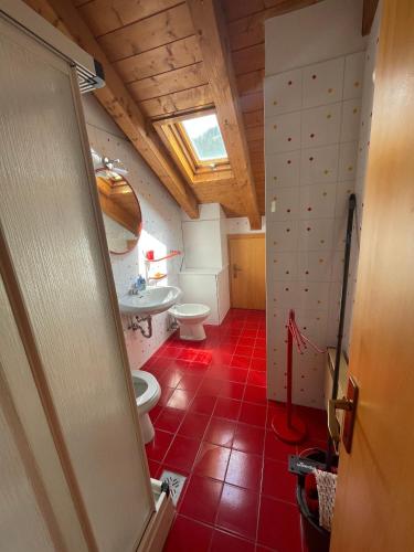 een badkamer met 2 toiletten en een wastafel bij Appartamento Monzoni in Pozza di Fassa