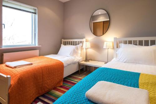 a bedroom with two beds and a mirror and a window at Clearwater 82, Primrose Bank in Somerford Keynes