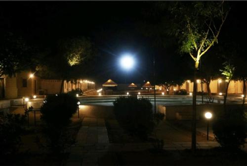 a night time view of a courtyard with a moon at Destination Desert Camp in Jaisalmer