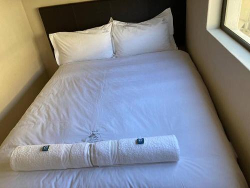 a white bed with pillows and a towel on it at Praia Da Lagosta in Langstrand