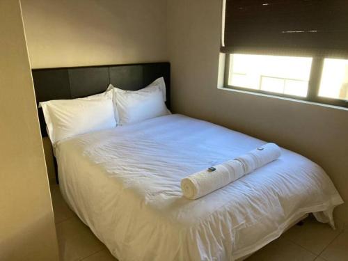 a white bed with a rolled up towel on it at Praia Da Lagosta in Langstrand