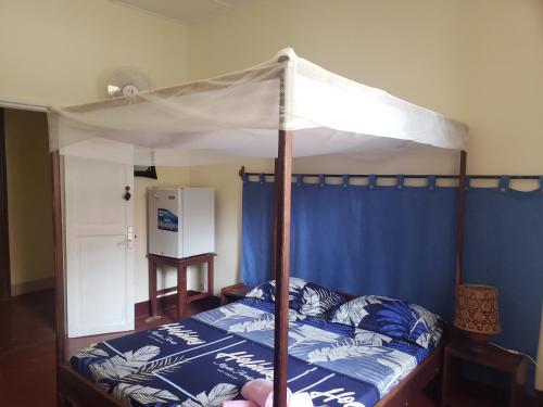 a bedroom with a bed with a canopy at Hotel Le Petit Paradis in Diego Suarez