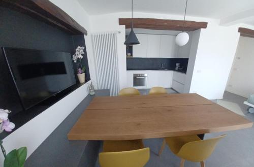 a dining room with a wooden table and yellow chairs at Casa vacanza La Fontana in Pedavena