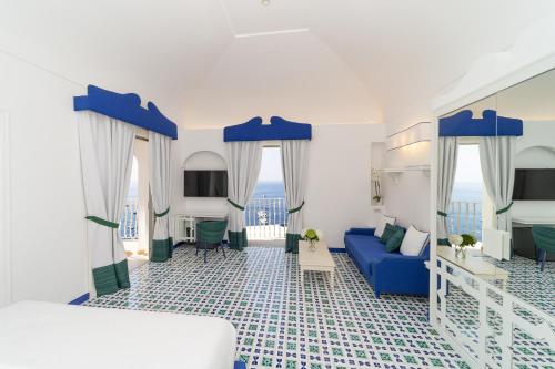 1 dormitorio con 1 cama azul y 1 sofá azul en Hotel Marincanto, en Positano