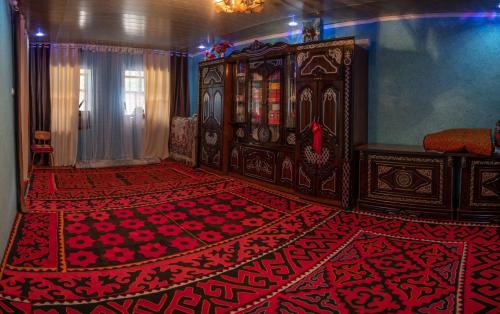 Zimmer mit einem Bett und einem roten Teppich in der Unterkunft Zhanysh Guest House 