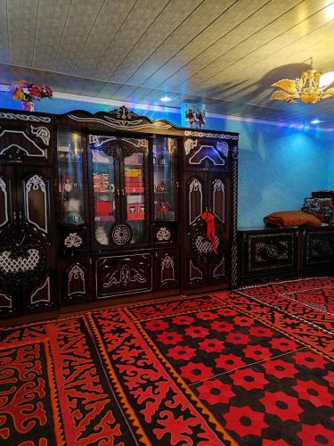 Zimmer mit einer Kommode und einem roten Teppich in der Unterkunft Zhanysh Guest House 