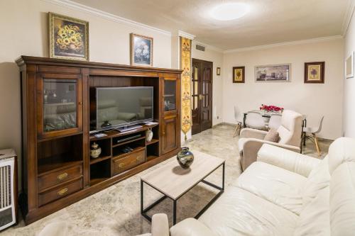 sala de estar con sofá blanco y TV en Gran Apartamento en el centro con Parking Gratis, en Córdoba
