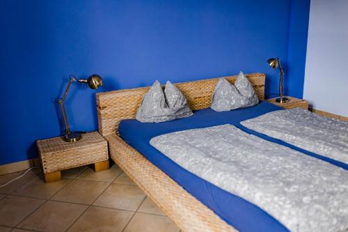 twee bedden in een kamer met een blauwe muur bij Tauglerei Appartement Malve in den Zauberbergen in Sankt Koloman