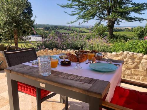einen Holztisch mit Speisen und Getränken darauf in der Unterkunft Pax et Amor Chambres d'hôtes de charme - Charming B&B in Mazerolles-du-Razès