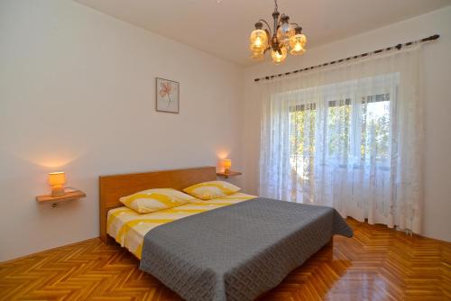 sypialnia z łóżkiem i dużym oknem w obiekcie House Slavko 2297 w mieście Grandići