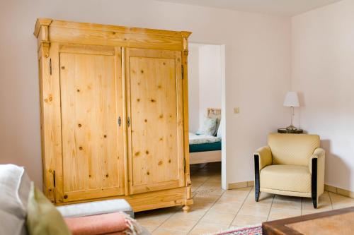 Armario de madera en una habitación con silla y cama en Tauglerei Appartement Bernstein in den Zauberbergen, en Sankt Koloman