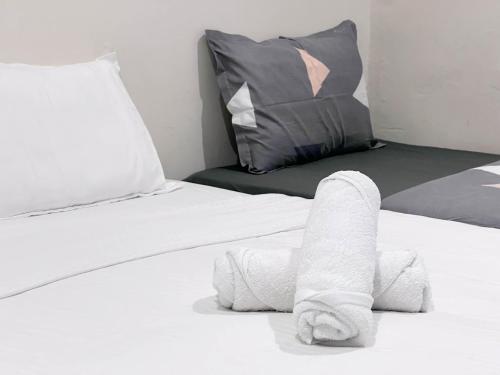 a pile of towels on a bed with a pillow at HUKM CoLiving 21 by Manhattan Group in Kuala Lumpur