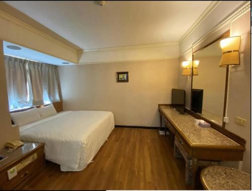 una camera d'albergo con letto e specchio di Tapeng Bay Holiday Hotel a Donggang