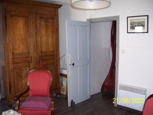 a room with a chair and a door and a guitar at Grande chambre, vue sur toits, cyclistes bienvenus in Béziers