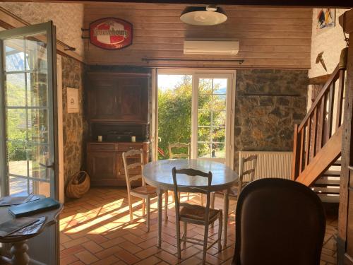 une salle à manger avec une table et des chaises et une fenêtre dans l'établissement Chalet 09, à Albiès