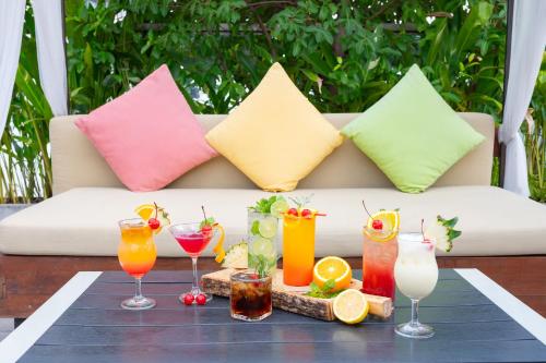 a tray of drinks on a table with colorful pillows at Galleria Sukhumvit 10 Bangkok by Compass Hospitality in Bangkok