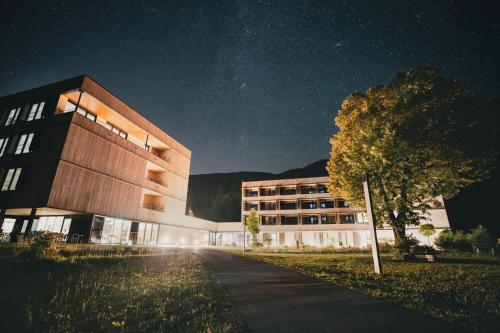 budynek w nocy z drzewem przed nim w obiekcie St Michael Alpin Retreat w mieście Matrei am Brenner