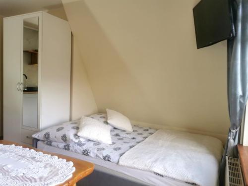 a small room with a bed and a mirror at Pokoje i Apartament U Ireny in Poronin
