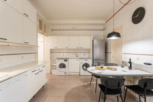 バルセロナにあるCanela Homes BARCELONA MODERNISTAのキッチン(テーブル、椅子、冷蔵庫付)