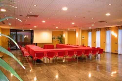 einen Konferenzraum mit roten Tischen und roten Stühlen in der Unterkunft Janus Hotel Fabriano in Fabriano