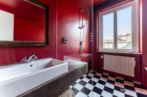 a bathroom with a large white tub and a window at Bagutta Suites - The Couper in Milan