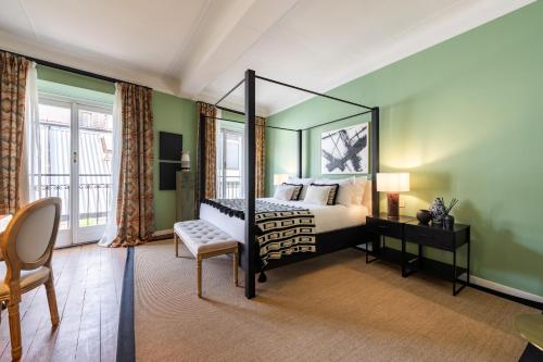 a bedroom with a canopy bed and a chair at Bagutta Suites - The Couper in Milan