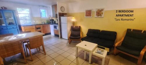 une cuisine et un salon avec une table et des chaises dans l'établissement Gîtes les Dryades, au calme, entre oliviers et piscine, à Salernes