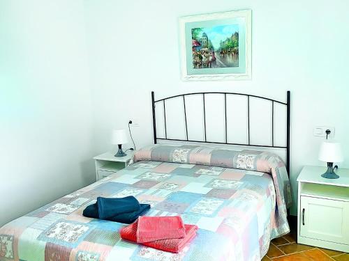 1 dormitorio con 1 cama con 2 almohadas en Casa piscina Privada Vallada & Barbacoa A&C, en Chiclana de la Frontera