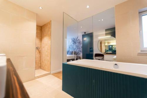 a large bathroom with a tub and a shower at Luxury Duplex Coeur de Mons 64-3 in Mons