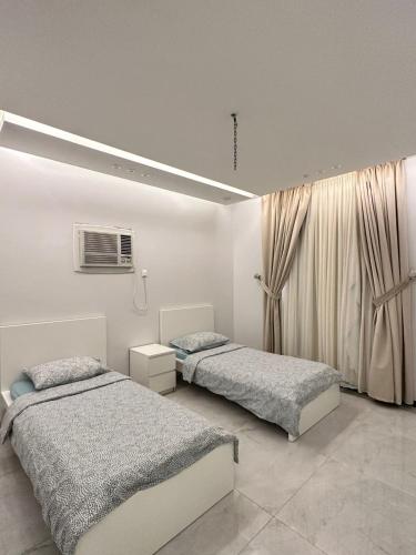 a bedroom with two beds and a window at المسك للوحدات الفندقيه الفاخره in Al Madinah