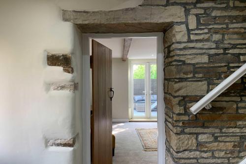 un pasillo con una pared de piedra y una puerta en Croft House Cottage, en Halifax