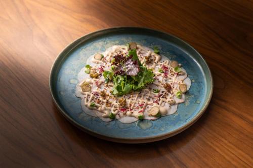 a plate of food with mushrooms and greens on a table at PortoBay Flores in Porto