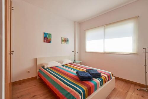 sypialnia z łóżkiem z kolorowym kocem w obiekcie Modern apartment in Parque das Nações w Lizbonie
