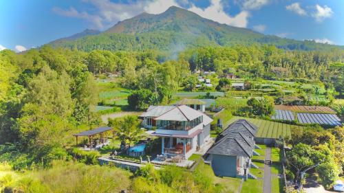 an aerial view of a house with a mountain in the background at Batur Volcano Guesthouse in Kintamani