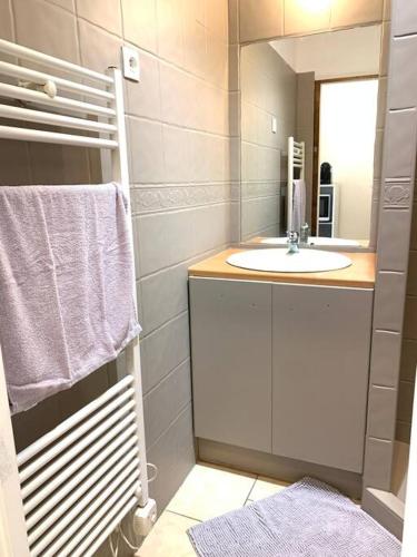 une salle de bain avec un lavabo et un miroir dans l'établissement Le Maillon - Bourg-de-Péage, à Bourg-de-Péage