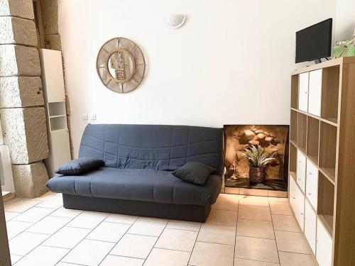 un sofá azul en una sala de estar con chimenea en Le Maillon - Bourg-de-Péage, en Bourg-de-Péage