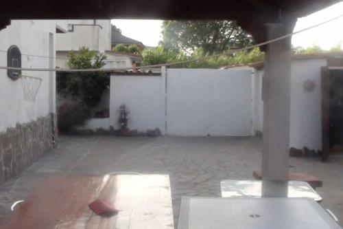 an empty backyard with a white fence and a basketball hoop at Villino con giardino a 10 minuti a piedi dal mare e vicino a Roma in Torvaianica